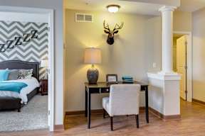 A bedroom with a bed, desk, and chair.