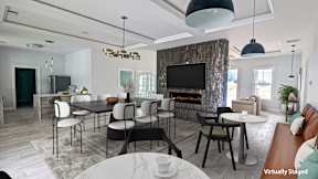 A modern living room with a stone fireplace and a dining area.