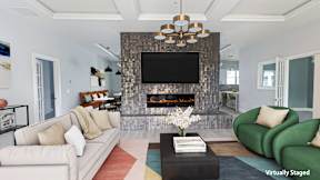 A living room with a fireplace and a television above it.