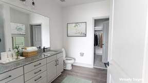 A bathroom with a toilet, sink, and a mirror.