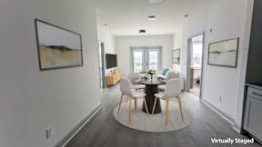 A modern dining room with a round table and chairs.