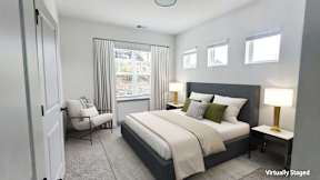 A bedroom with a bed, a chair, and a lamp.