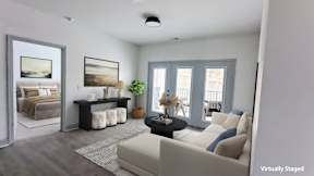 A living room with a couch, a coffee table, and a painting on the wall.