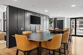 A black dining table with yellow chairs in a room.