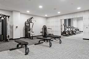 A black and white photo of a gym with a variety of equipment.