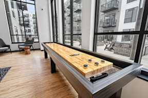 A shiny wooden table with black and yellow game pieces on it.
