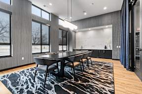 A modern dining room with a large table and chairs.