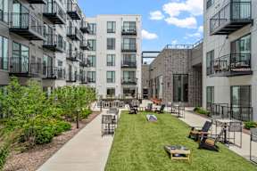 A sunny day at a modern apartment complex with a grassy courtyard.