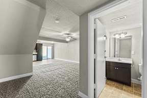 A bathroom with a sink, mirror, and toilet is shown.