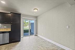 A kitchen with black cabinets and a tiled floor.