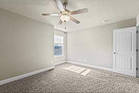 A room with a ceiling fan and a door.