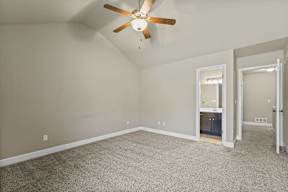 A room with a ceiling fan and carpeted floor.