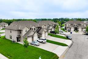 A row of houses with cars parked in front.