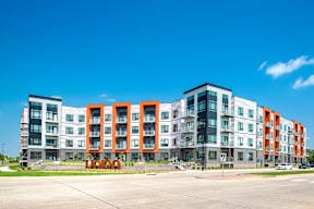 Luxury Apartments in Berkley Riverfront, MO - Union Berkley - Exterior of Apartment Complex with Paved Driveway, Sidewalks, Landscaping, and Property Signage.