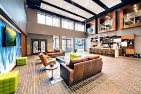 A large room with a long couch and a table in the middle.
