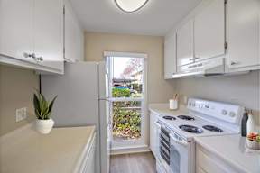 A kitchen with white appliances and cabinets.