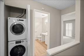 A washing machine is in the doorway of a room.