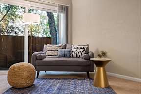 A grey couch with a pillow that says 