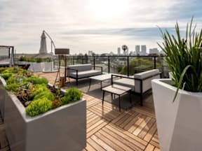 A rooftop patio with a table and chairs and a view of the city.