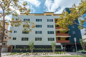 A modern multi-story building with a white facade and colorful accents.