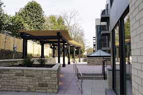 A building with a black awning and a stone wall.