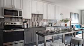 A modern kitchen with a dining table set for two.