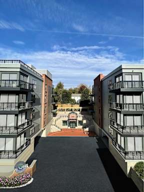 A courtyard between two buildings with a bench and a planter.