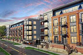 A street view of a row of modern apartment buildings.