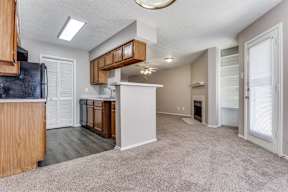 A kitchen with wooden cabinets and a black refrigerator.