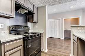 A kitchen with a black stove top oven and a white counter top.