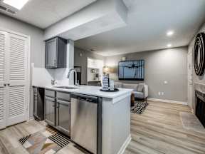 A modern kitchen with a wooden floor and stainless steel appliances.