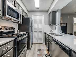 A kitchen with black appliances and white countertops.