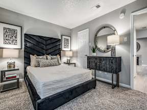 A bedroom with a large bed and a dresser.