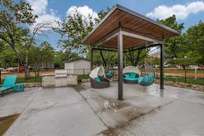 A playground with a wooden roof and a slide.