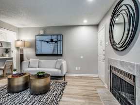 A living room with a fireplace and a painting on the wall.