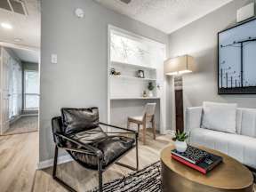 A black leather chair sits in a well-lit room with a coffee table in front of it.