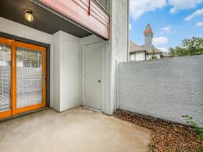A patio area with a white door and orange window blinds.