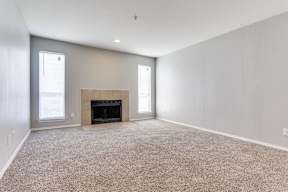 A large empty room with a fireplace in the middle.
