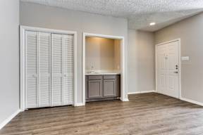 A room with a wooden floor and a cabinet in the middle.