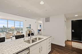 A modern kitchen with a large island and a view of the city.