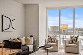 A living room with a large window overlooking a cityscape.