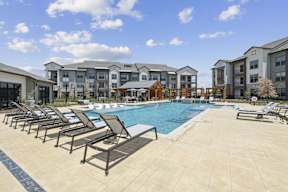 a swimming pool with lounge chairs and outdoor dining