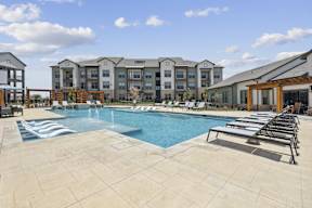 a swimming pool with lounge chairs and cabanas