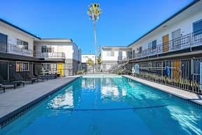 A pool in the middle of a courtyard surrounded by buildings.