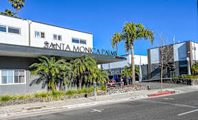 A street view of the Santa Monica Palms building with a clear blue sky.