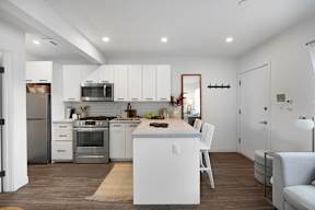 A modern kitchen with white cabinets and stainless steel appliances.