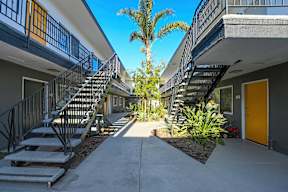 A sunny day in a courtyard surrounded by buildings with staircases.