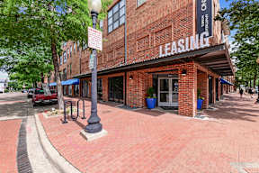 A red brick building with a sign that says "LEASING" on it.