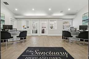 A room with a black and white color scheme and a rug that says "The Sanctuary Highland Oaks".