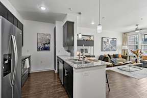 A modern kitchen with a refrigerator, sink, and cabinets.